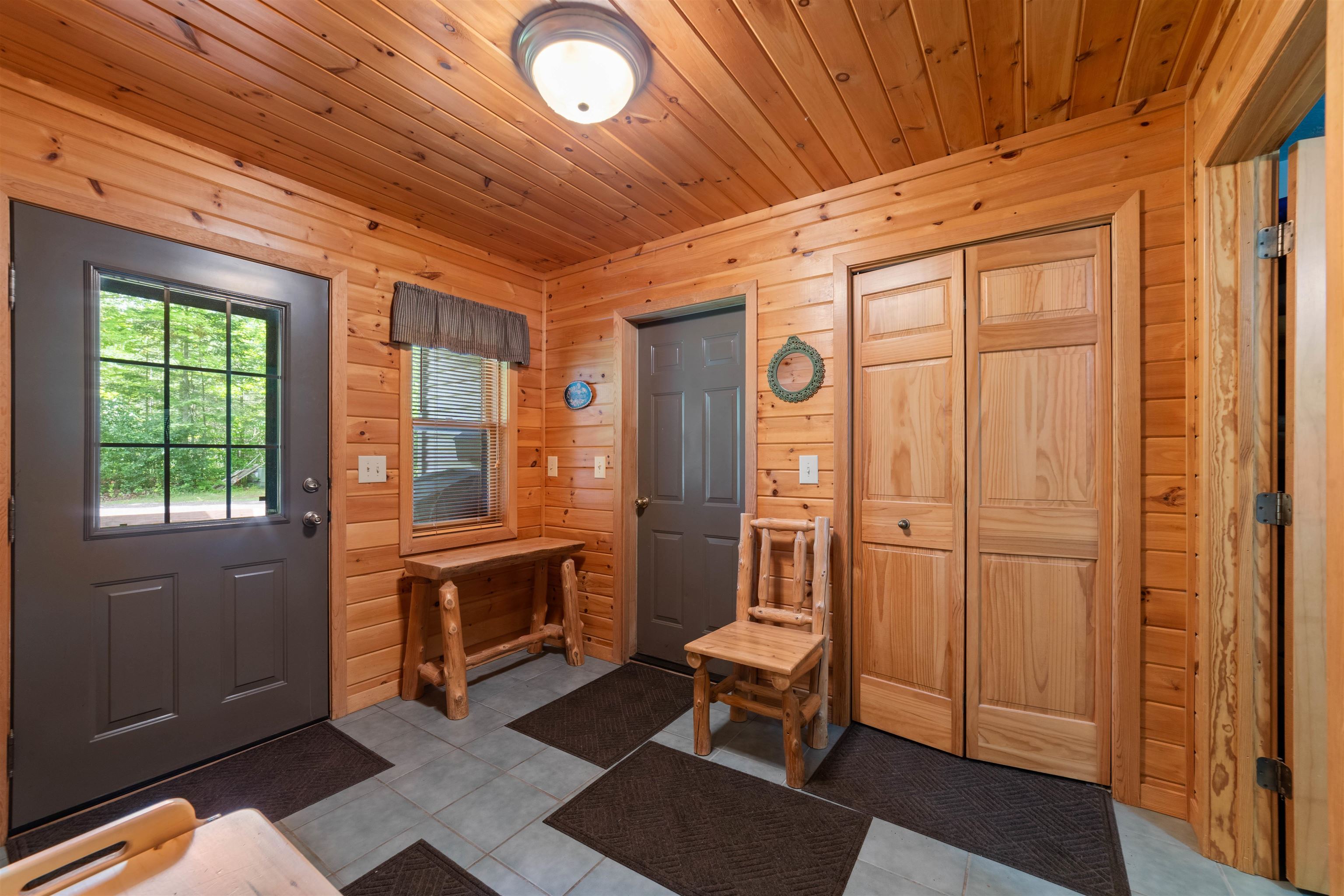 4930 Mini Power Road Duluth, MN 55803 - Photo 10 of 36 Entrance foyer with dark tile patterned floors, wooden walls, and wooden ceiling
