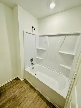 a bathroom with a tub and shower