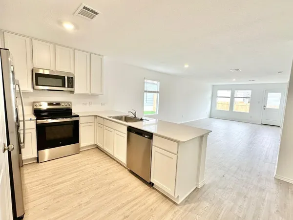a kitchen with granite countertop white cabinets and stainless steel appliances