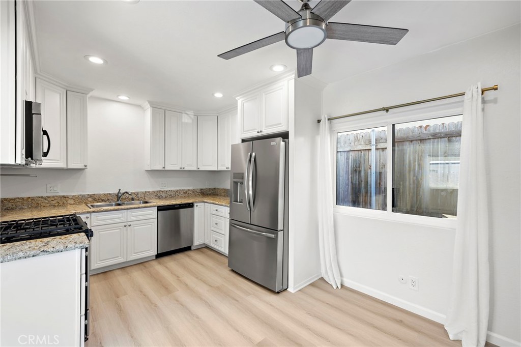 33771 Copper Lantern Street Dana Point, CA 92629 - Photo 5 of 16 a kitchen with granite countertop stainless steel appliances a refrigerator cabinets and wooden floor
