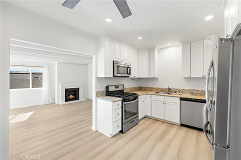 a kitchen with granite countertop a stove top oven and refrigerator