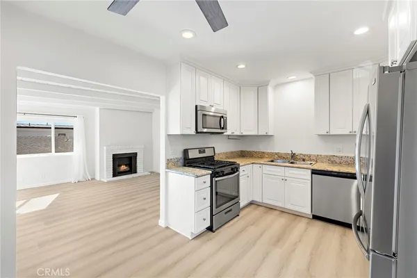 a kitchen with granite countertop a stove top oven and refrigerator