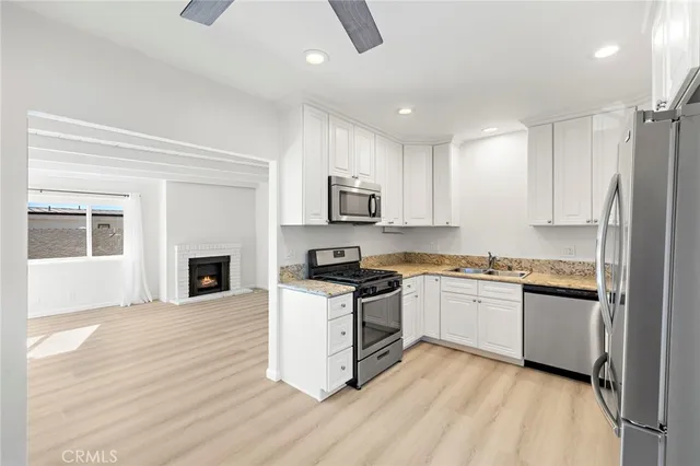 a kitchen with granite countertop a stove top oven and refrigerator