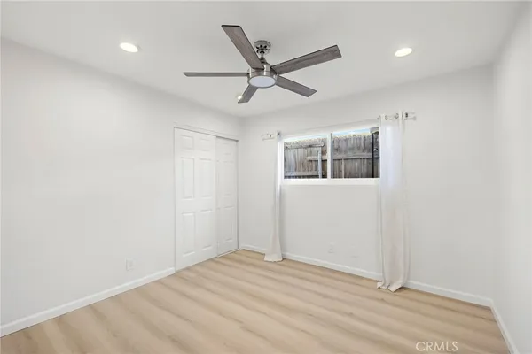 a view of a livingroom with a ceiling fan & wooden floor