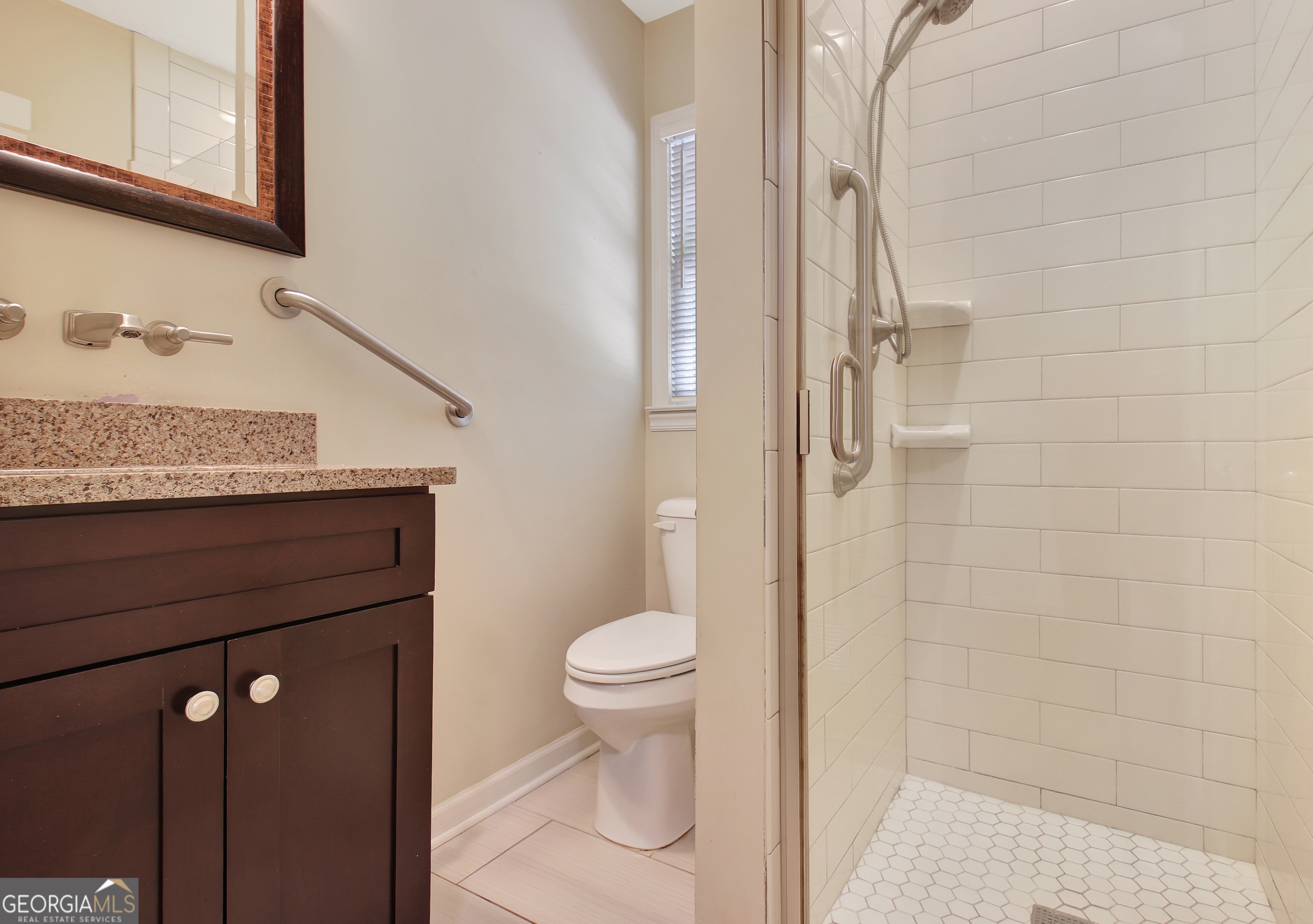 717 Tyrone Road Tyrone, GA 30290 - Photo 18 of 58 a bathroom with a granite countertop toilet and a shower