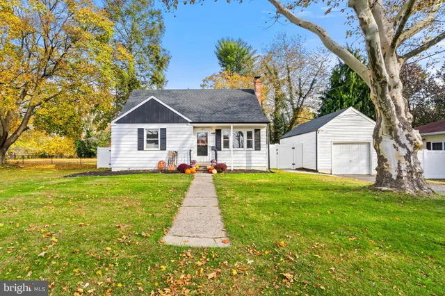 a front view of a house with a yard and trees