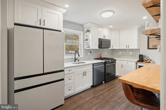 a kitchen with stainless steel appliances a refrigerator sink and microwave