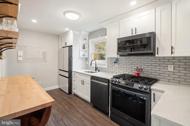a kitchen with stainless steel appliances a stove sink microwave and cabinets