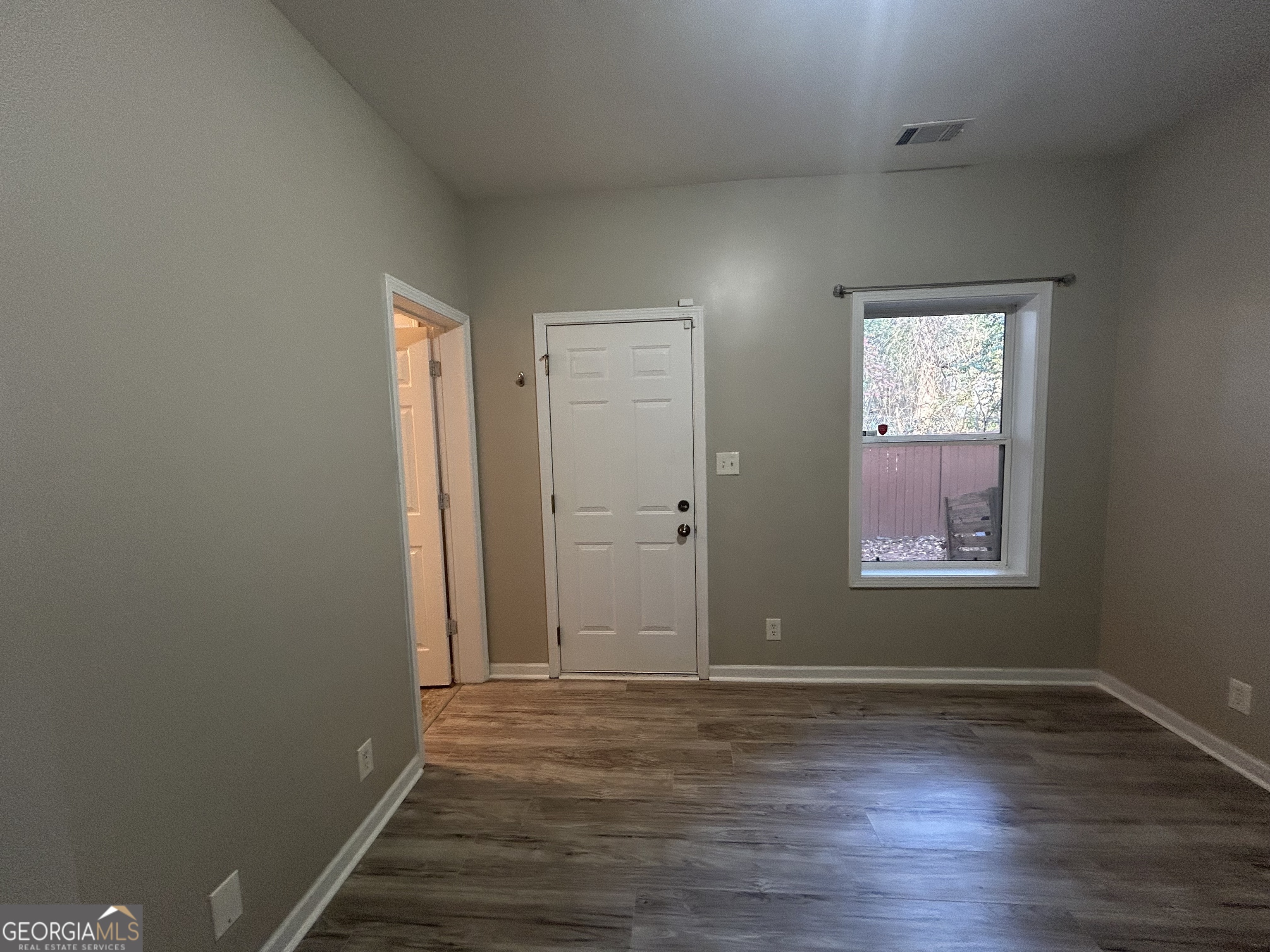 3086 Lauren Parc Road Decatur, GA 30032 - Photo 3 of 5 an empty room with wooden floor and windows