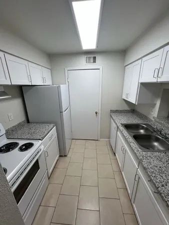 a kitchen with a stove top oven and cabinets