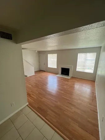 en empty room with wooden floor and fireplace