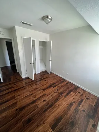 a view of empty room with wooden floor