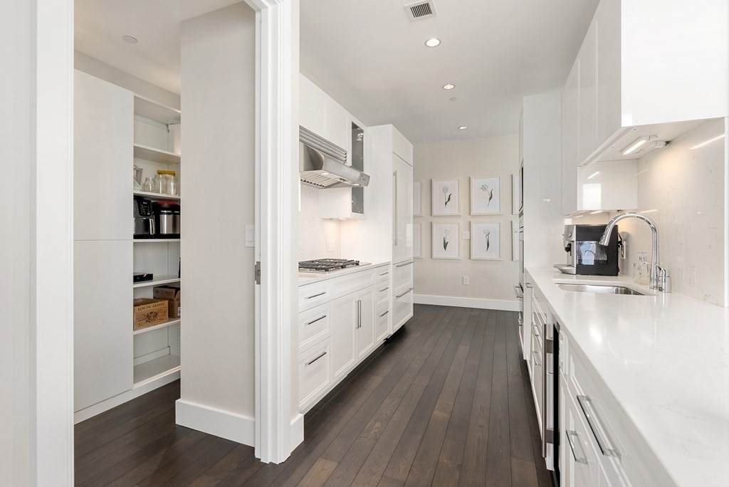 22 Liberty Drive, Unit 6A Boston, MA 02210 - Photo 11 of 42 a kitchen with white cabinets and stainless steel appliances