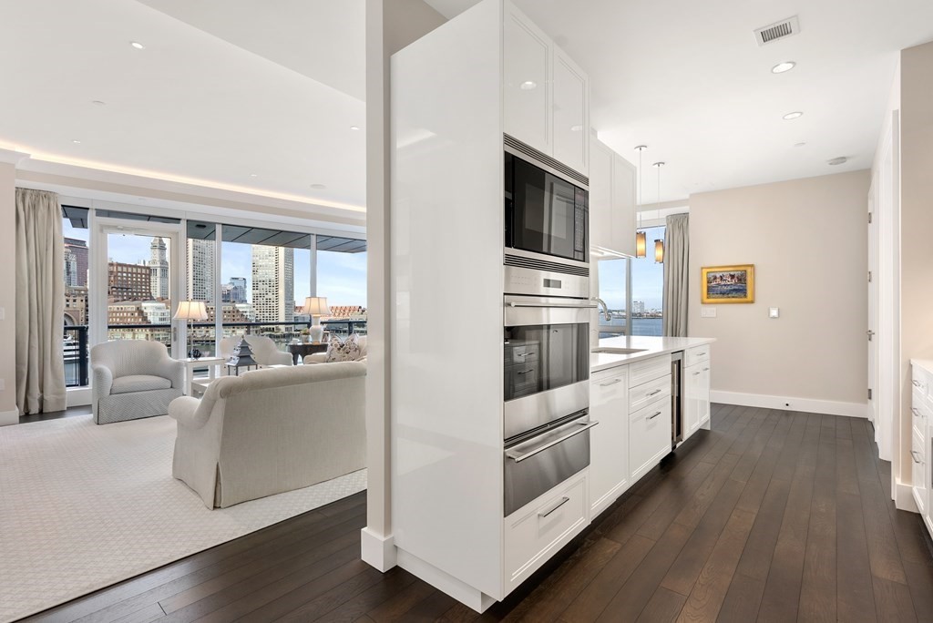 22 Liberty Drive, Unit 6A Boston, MA 02210 - Photo 8 of 42 a kitchen with stainless steel appliances a white stove top oven a sink dishwasher and white cabinets with wooden floor