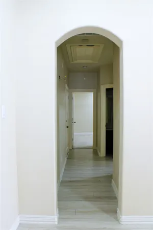 a view of a hallway with wooden floor