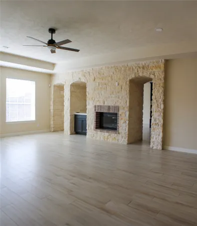 wooden floor fireplace and windows in an empty room