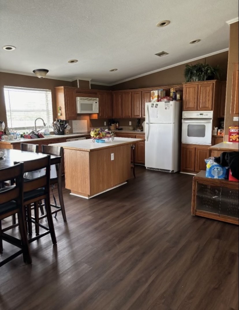 4021 Baker Road Needville, TX 77461 - Photo 14 of 14 a kitchen with cabinets wooden floor and stainless steel appliances