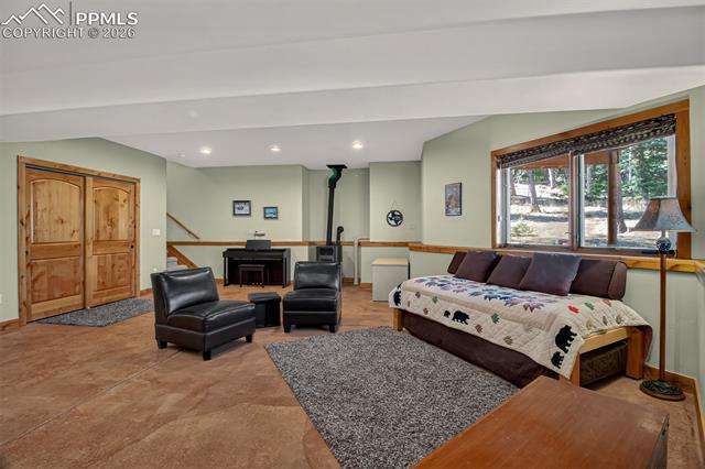 255 Summit Road Manitou Springs, CO 80829 - Photo 37 of 48 Recreation room on the lower level with a murphy bed, 3/4 bathroom, a pellet stove and access to/from the garage