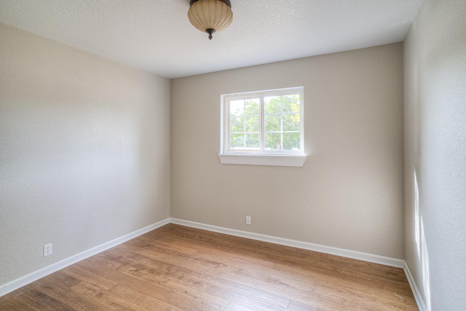 5463 Hankins Road Williams, CA 95987 - Photo 21 of 62 an empty room with wooden floor and windows