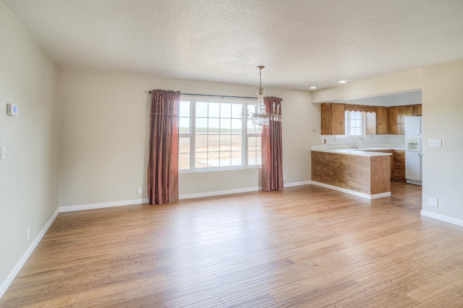 5463 Hankins Road Williams, CA 95987 - Photo 10 of 62 an empty room with wooden floor and fireplace