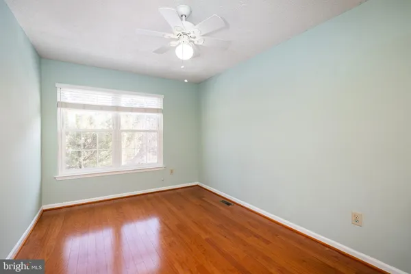 an empty room with wooden floor and window