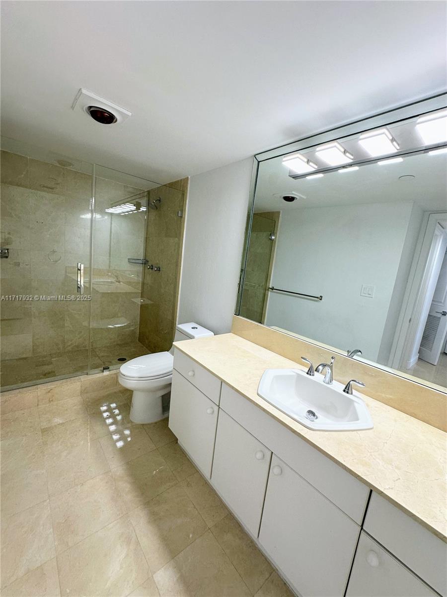 8855 Collins Avenue, Unit 8A Surfside, FL 33154 - Photo 12 of 15 a bathroom with a double vanity sink toilet and shower