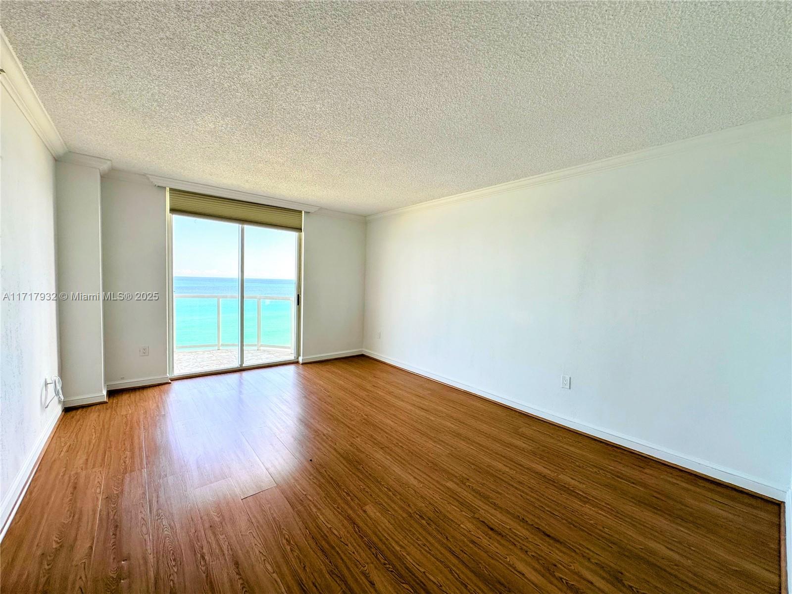 8855 Collins Avenue, Unit 8A Surfside, FL 33154 - Photo 14 of 15 a view of an empty room with wooden floor and a window