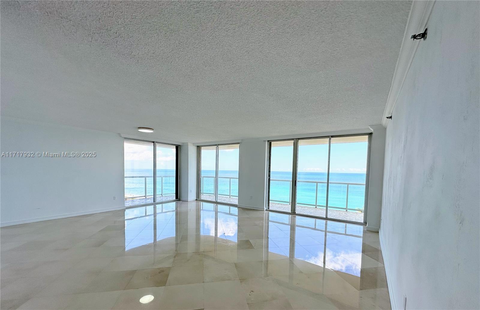 8855 Collins Avenue, Unit 8A Surfside, FL 33154 - Photo 4 of 15 an empty room with floor to ceiling windows and city view