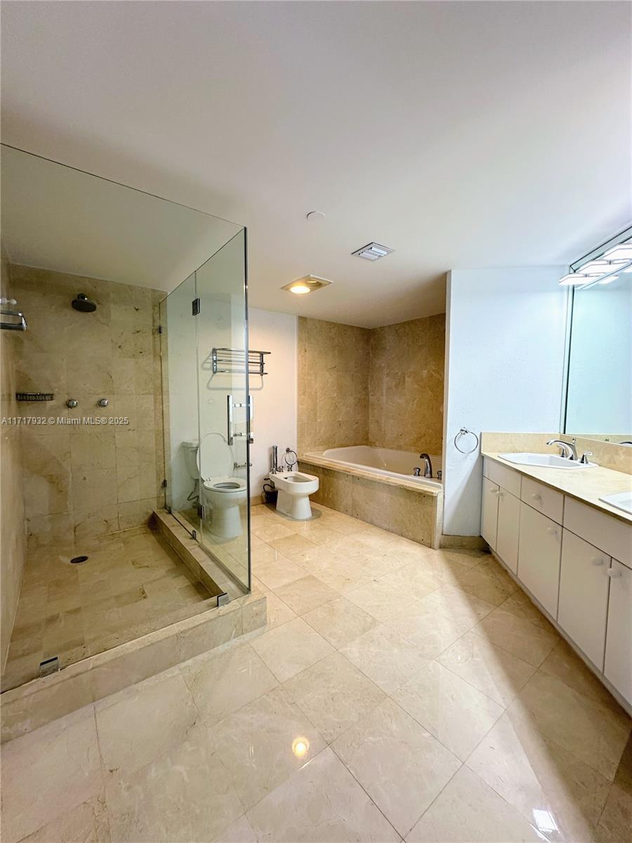 8855 Collins Avenue, Unit 8A Surfside, FL 33154 - Photo 10 of 15 a bathroom with a tub shower sink and mirror