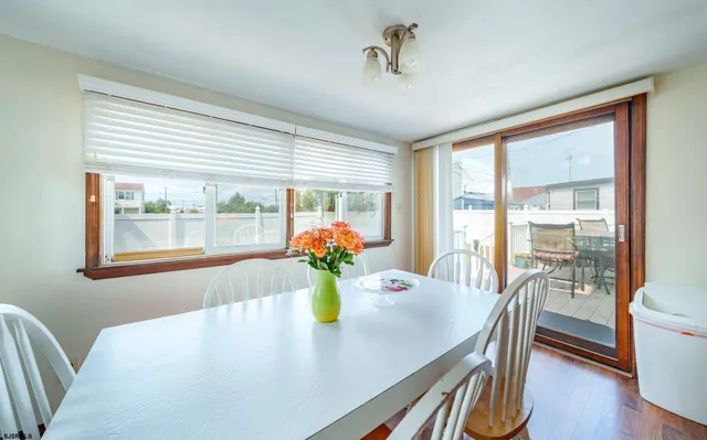 a view of a dining room with furniture a potted plant and wooden floor