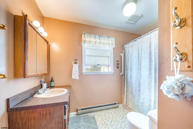 a bathroom with a sink vanity mirror and toilet