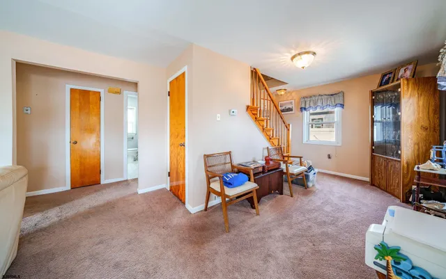 a view of an empty room with furniture and a window