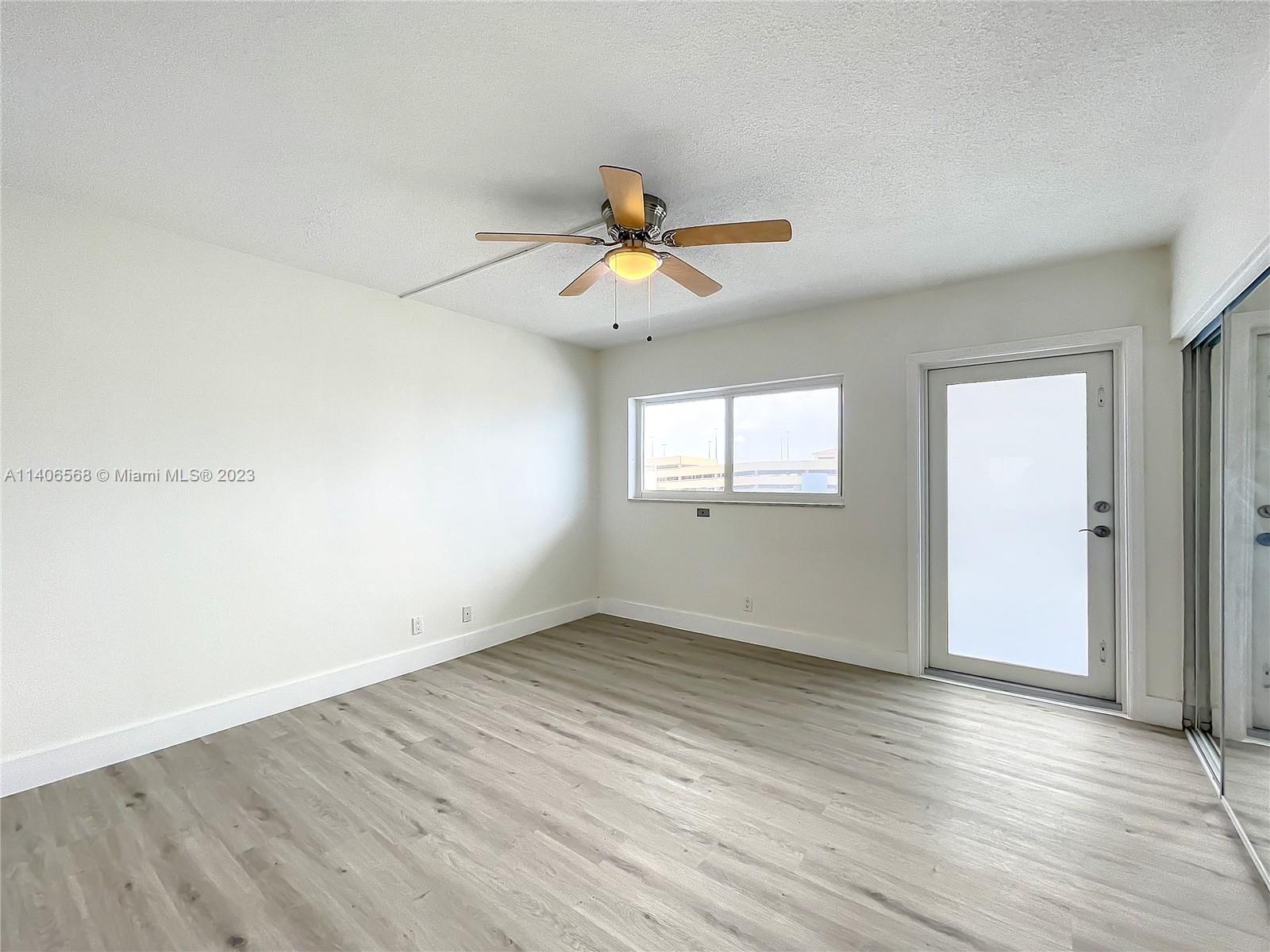 320 South Surf Road, Unit 502 Hollywood, FL 33019 - Photo 7 of 45 an empty room with wooden floor and windows