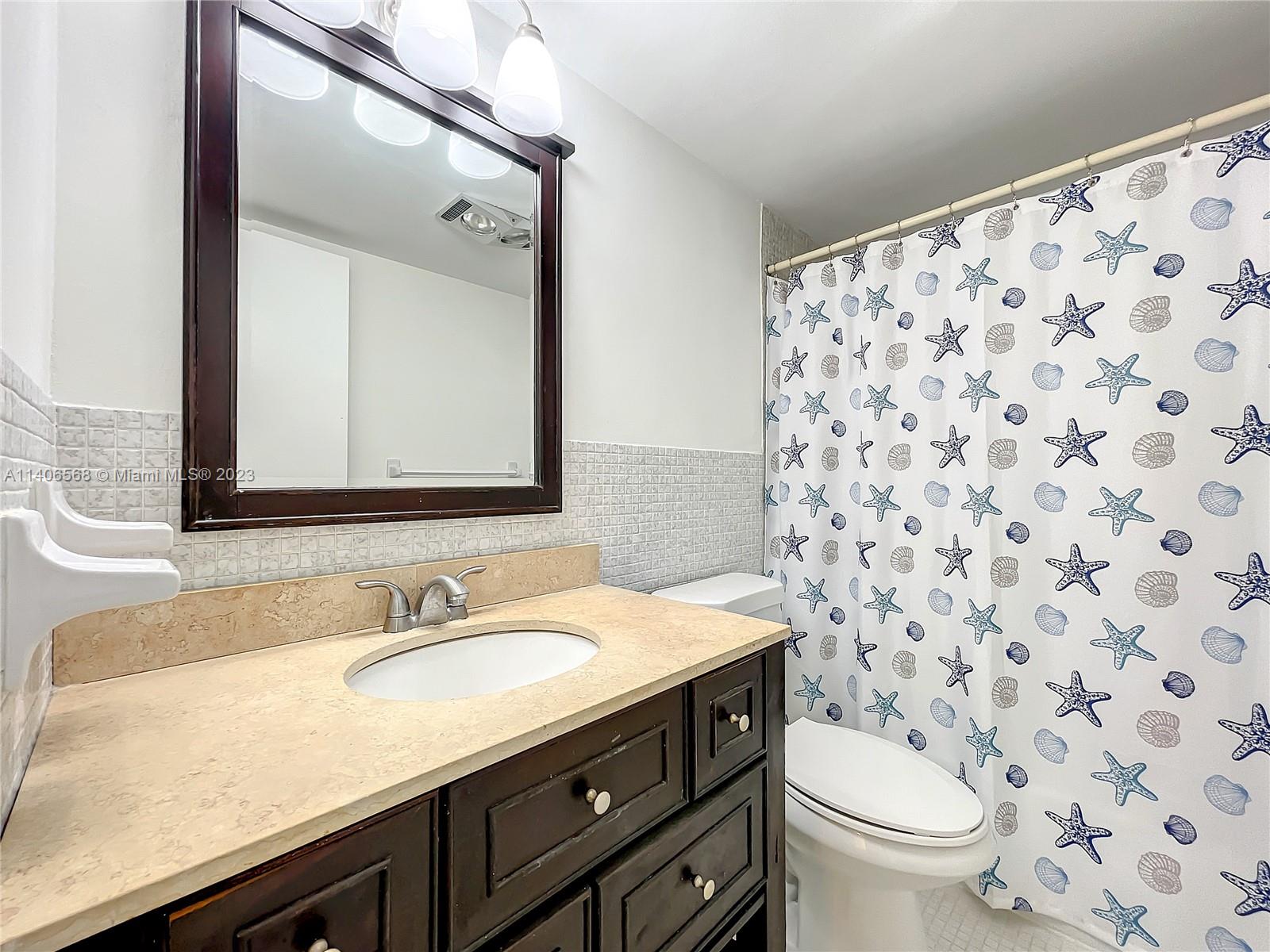 320 South Surf Road, Unit 502 Hollywood, FL 33019 - Photo 10 of 45 a bathroom with a granite countertop sink a toilet and a mirror