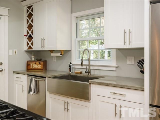 835 Brookside Drive Raleigh, NC 27604 - Photo 13 of 24 a kitchen with stainless steel appliances a sink a stove and white cabinets next to a window