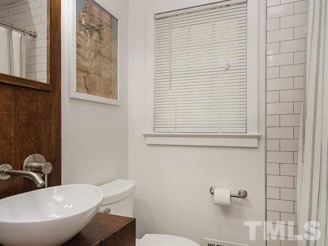 835 Brookside Drive Raleigh, NC 27604 - Photo 15 of 24 a bathroom with a toilet a sink and mirror
