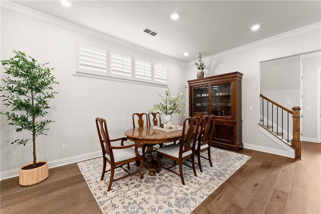 504 Pearl Street Cumming, GA 30040 - Photo 17 of 52 a dining room with furniture potted plants and wooden floor