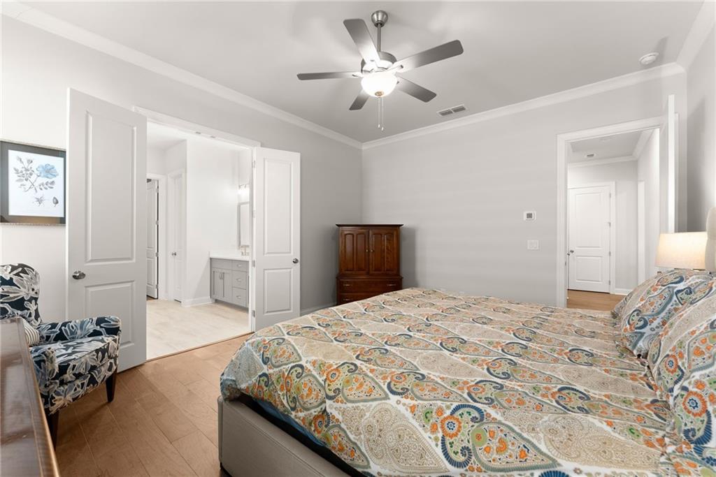 504 Pearl Street Cumming, GA 30040 - Photo 24 of 52 a spacious bedroom with a bed and a chandelier