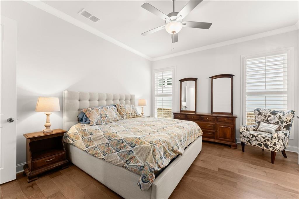 504 Pearl Street Cumming, GA 30040 - Photo 25 of 52 a bedroom with a large bed and a chandelier fan
