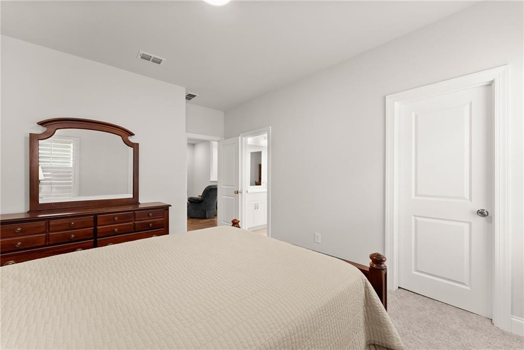 504 Pearl Street Cumming, GA 30040 - Photo 35 of 52 a bedroom with a bed and a large mirror