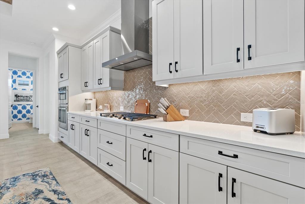12480 Meribel Street Venice, FL 34293 - Photo 10 of 24 a kitchen with granite countertop white cabinets and stainless steel appliances