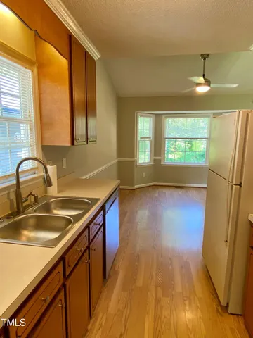 a view of a kitchen with a sink and wooden floor