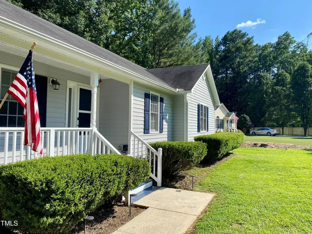 a view of a house with backyard and sitting area