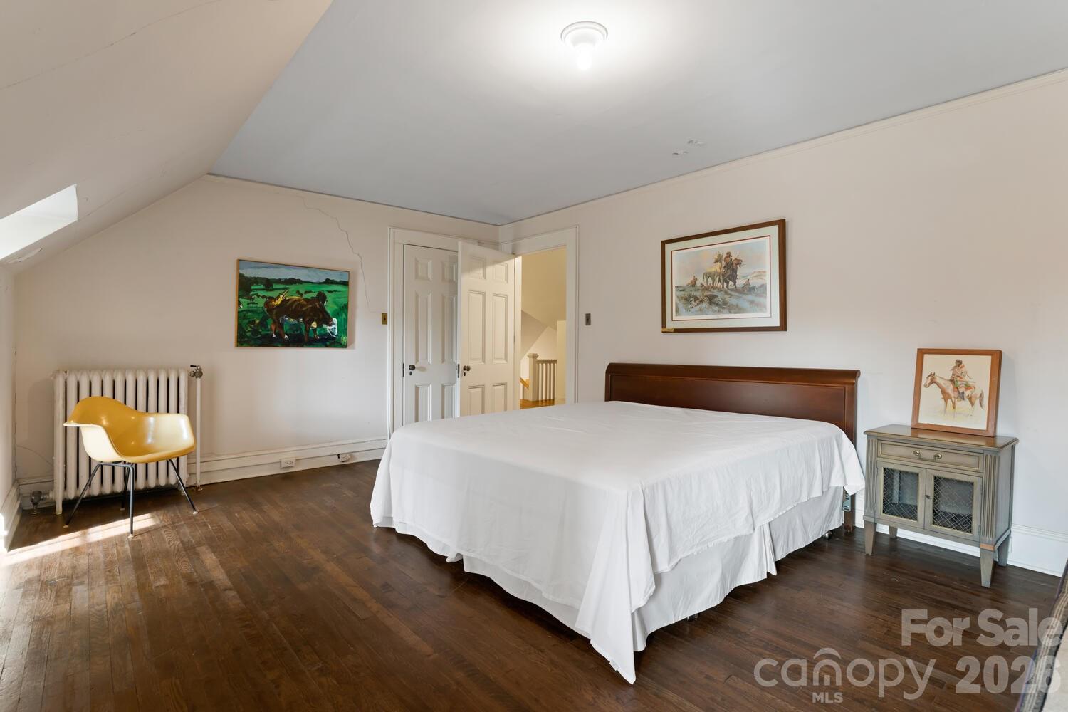 407 Vanderbilt Road Asheville, NC 28803 - Photo 44 of 48 a spacious bedroom with a bed and a table with chair
