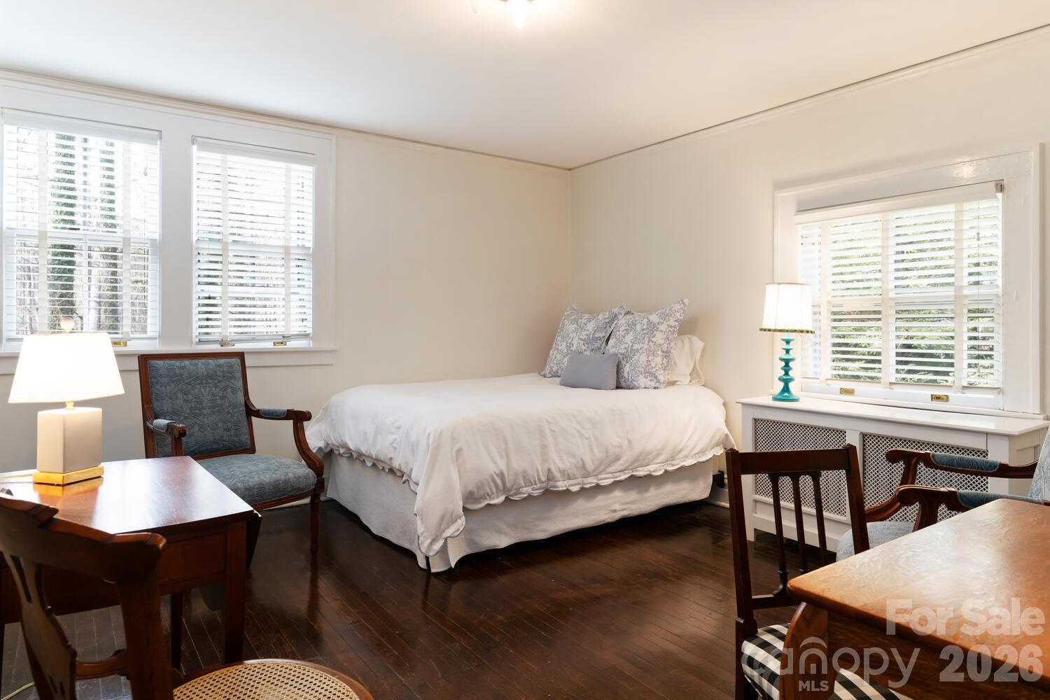 407 Vanderbilt Road Asheville, NC 28803 - Photo 48 of 48 a bedroom with a bed a table and chairs with wooden floor