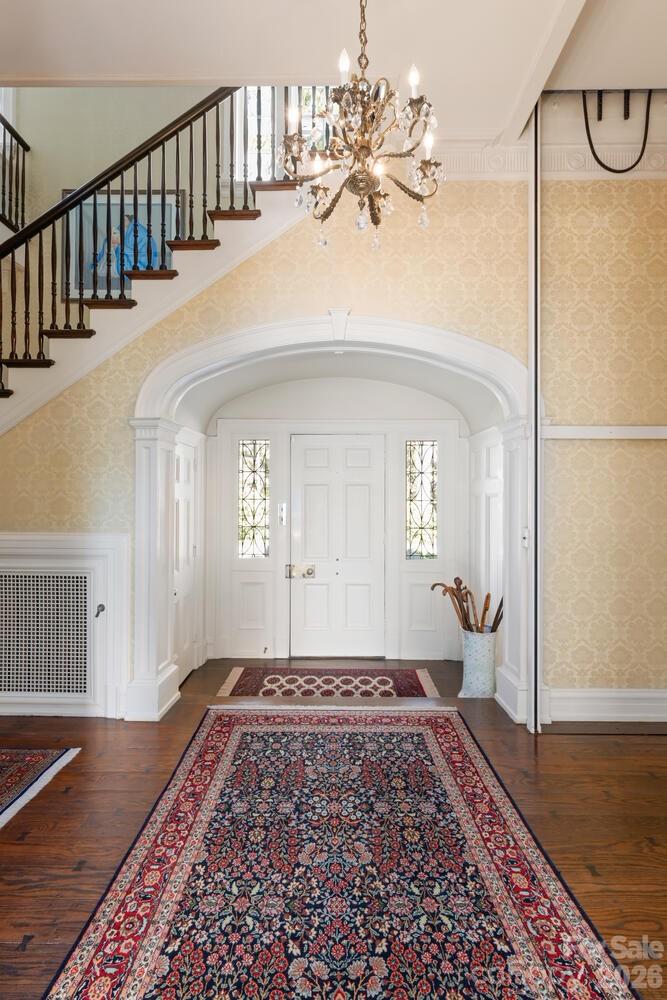 407 Vanderbilt Road Asheville, NC 28803 - Photo 6 of 48 a view of a hallway with wooden floor and a chandelier