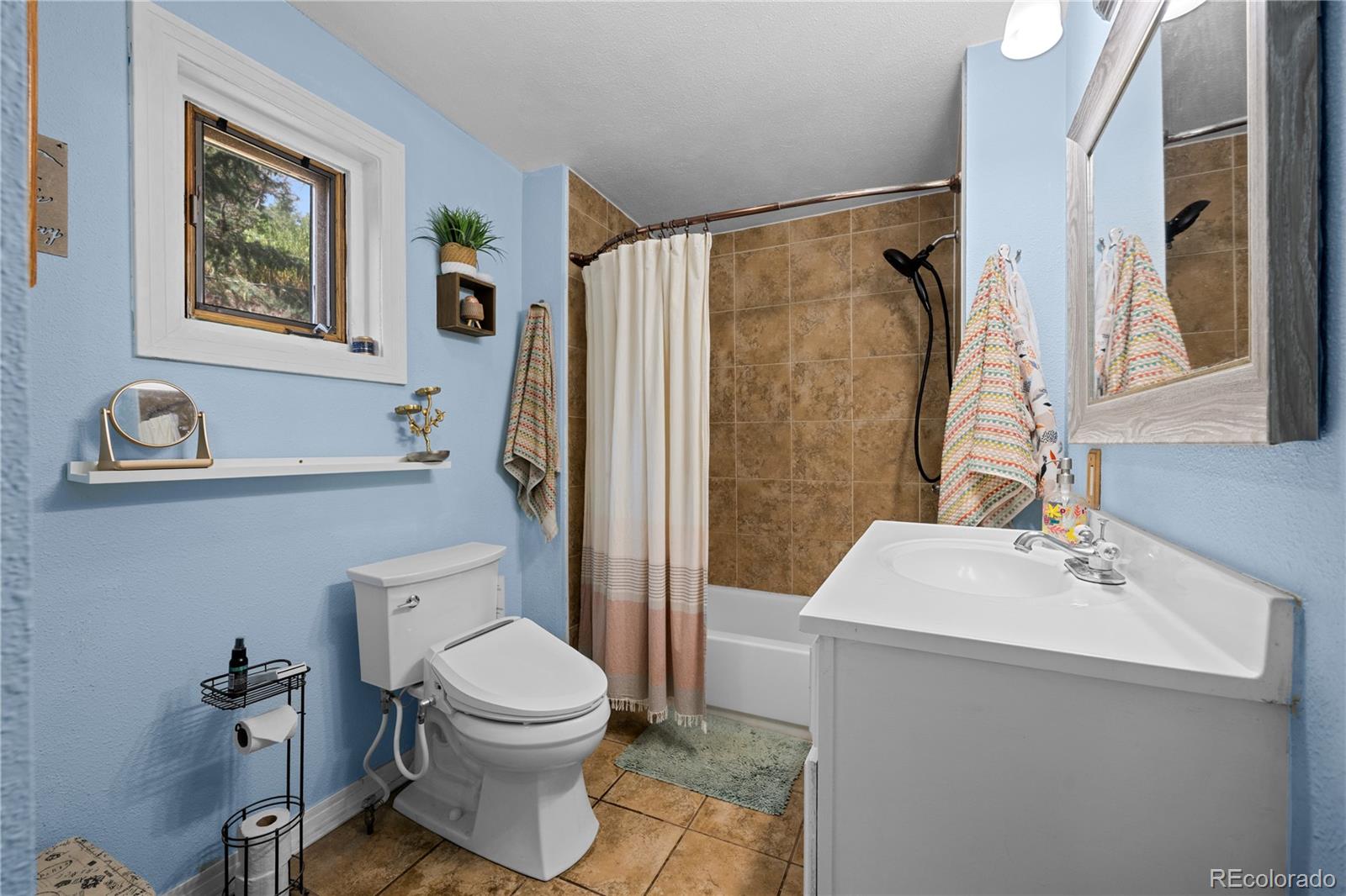 5211 Parmalee Gulch Road Indian Hills, CO 80454 - Photo 19 of 43 a bathroom with a sink toilet and shower