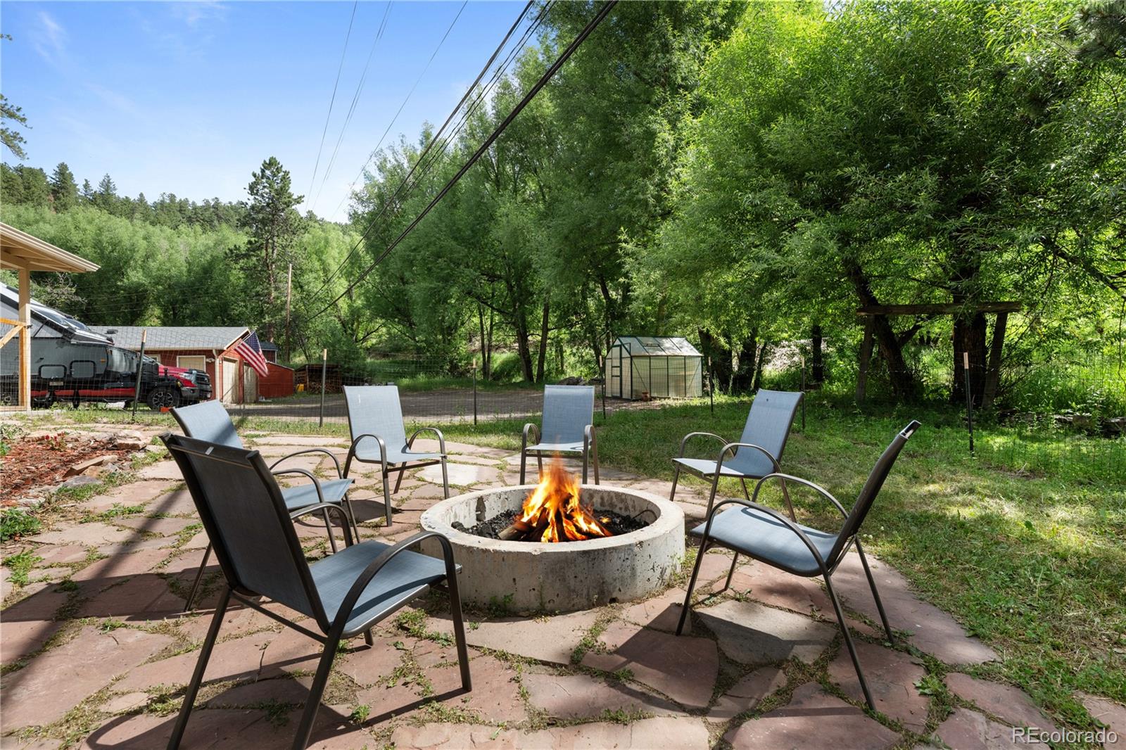 5211 Parmalee Gulch Road Indian Hills, CO 80454 - Photo 25 of 43 a chairs and a table in a backyard