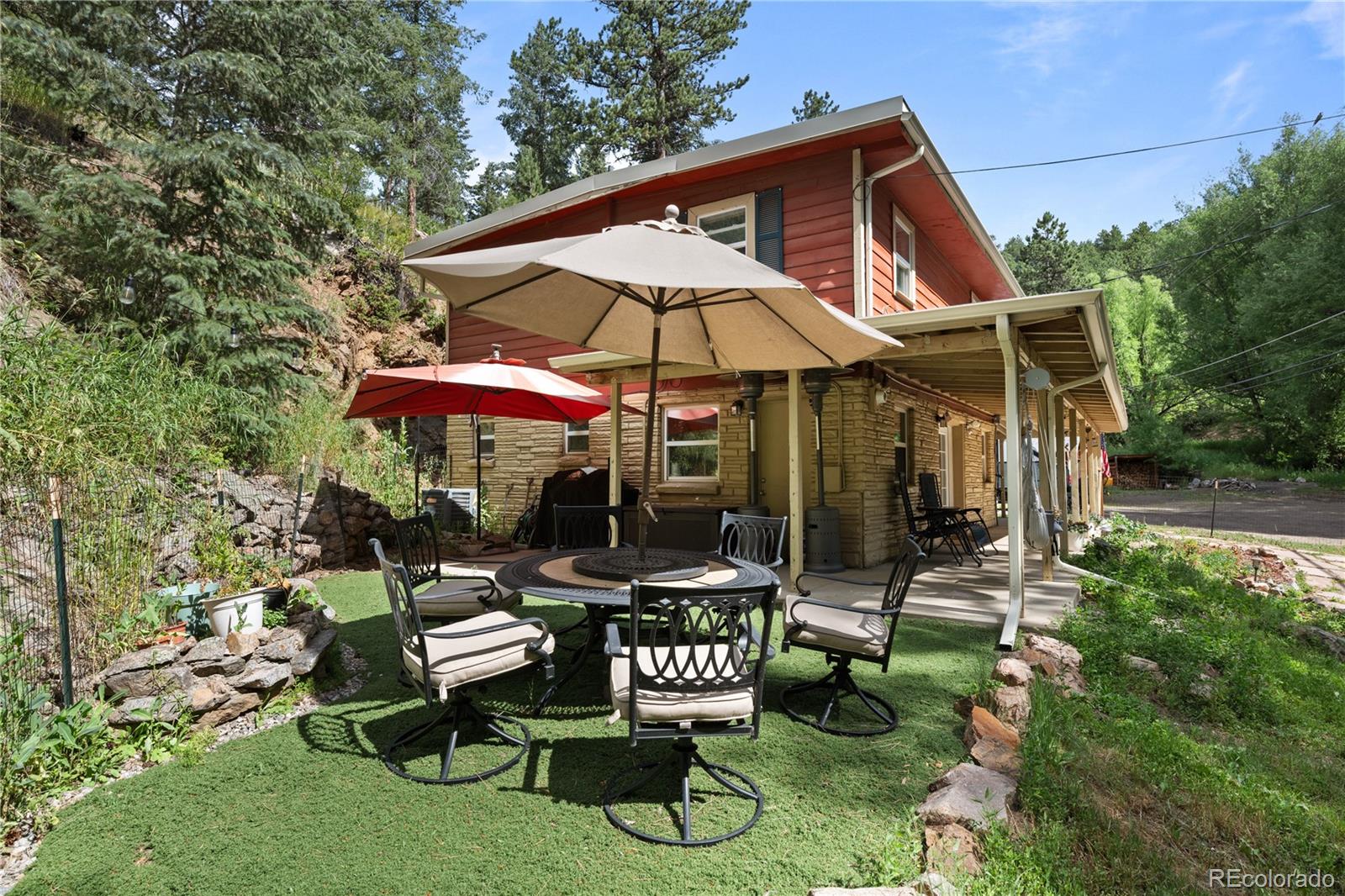 5211 Parmalee Gulch Road Indian Hills, CO 80454 - Photo 26 of 43 a patio with a table and chairs under an umbrella
