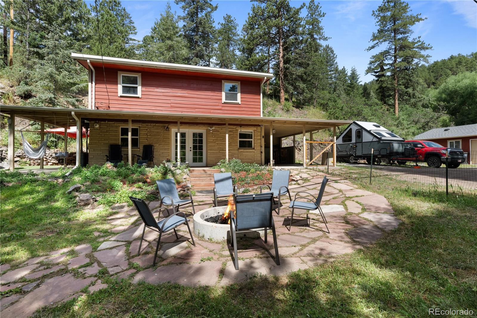 5211 Parmalee Gulch Road Indian Hills, CO 80454 - Photo 3 of 43 a view of a house with backyard sitting area and garden